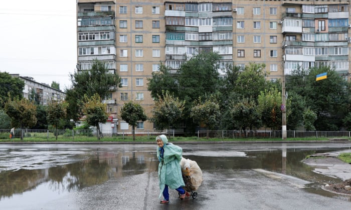 An elderly Ukrainian woman drags a cart full of plastic bottles in Kramatorsk in the Donetsk region of Ukraine.
