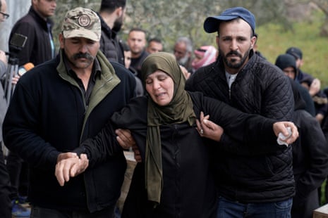 Mourners assist a relative of Fakher Bani Jaber, during his funeral in the village of Aqraba, near the occupied West Bank city of Nablus, Wednesday, 20 March.