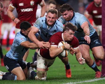 Huw Jones dives over to score his second try despite the efforts of three defenders