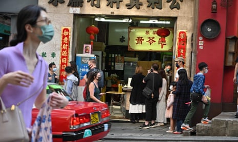People queue up at a tea shop on a street in Hong Kong