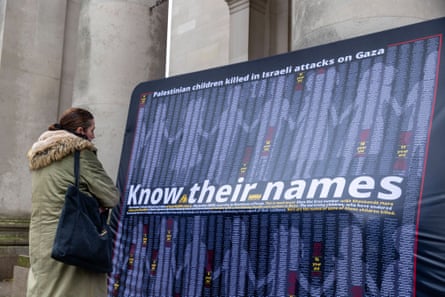 A woman stands in front of a poster saying ‘Know their names’ with a list of the children killed in the Gaza conflict A woman stands in front of a poster saying ‘Know their names’ with a list of the children killed in the Gaza conflict