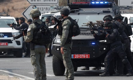 Israeli soldiers take position on the main road near the border with Gaza.
