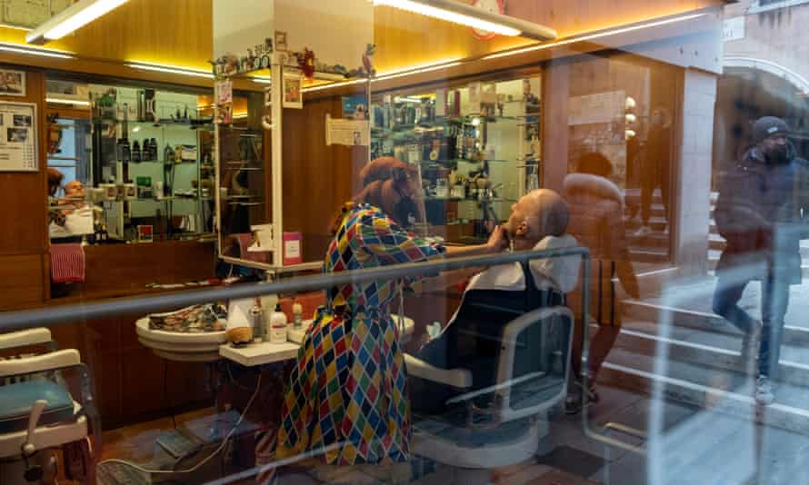 A hairdresser wearing a traditional harlequin costume