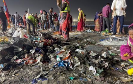 Rubbish is strewn across the floor in front of a crowd of people, some of them wearing hi-vis