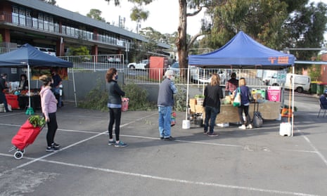 People wearing masks queue 1.5m apart at a stall at Eltham Farmers Market
