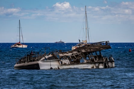 A burnt catamaran lies offshore in Lahaina. Experts have warned that toxic contamination from the fire will damage the delicate marine ecosystem.
