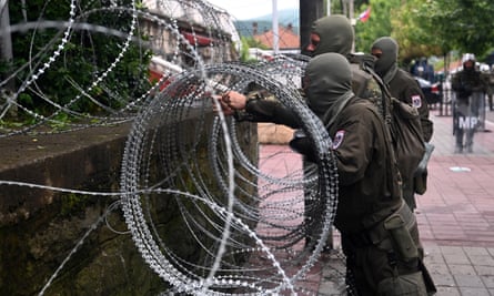 Austrian soldiers with the Nato-led peacekeeping Kosovo Force set up a razor wire fence in front of the municpal building in Zvecan on 31 May.