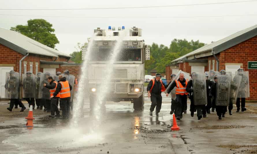 Police officers training with a water cannon