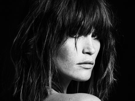 Gemma Arterton in profile looking over a bare shoulder, with dark, straightened hair: in black and white