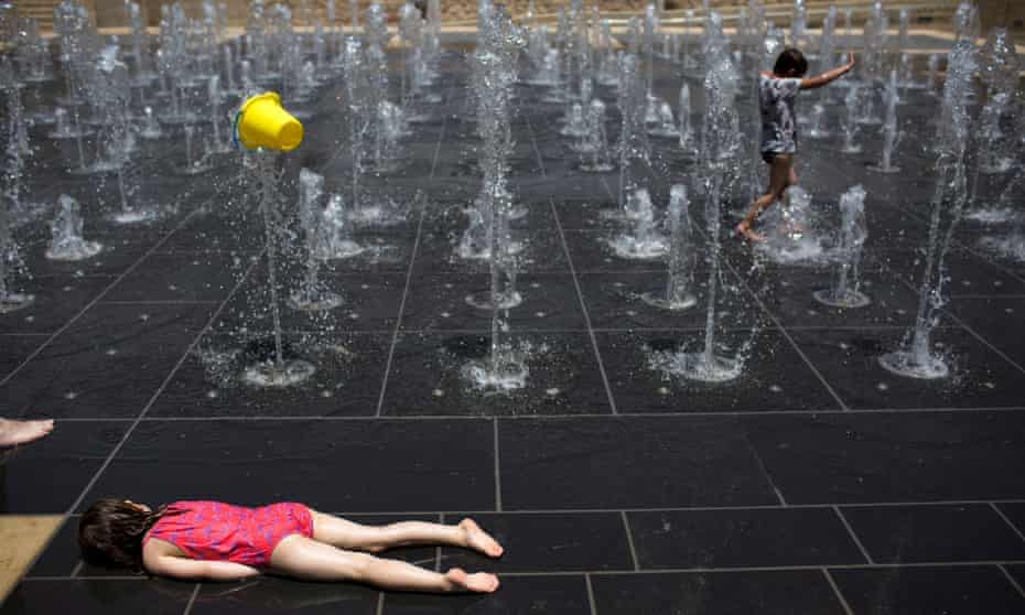 Young children playing in a fountain during a heatwave