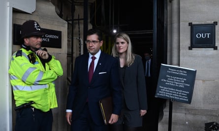 Frances Haugen leaves the Houses of Parliament in London, with a police officer standing by