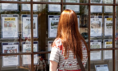 A young woman looks into the window of a letting agent.