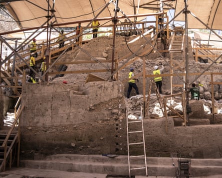 People in yellow hi-vis vests carry out excavation work