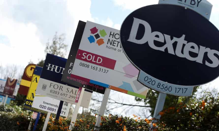 Property estate agent sales and letting signs are seen attached to railings in London