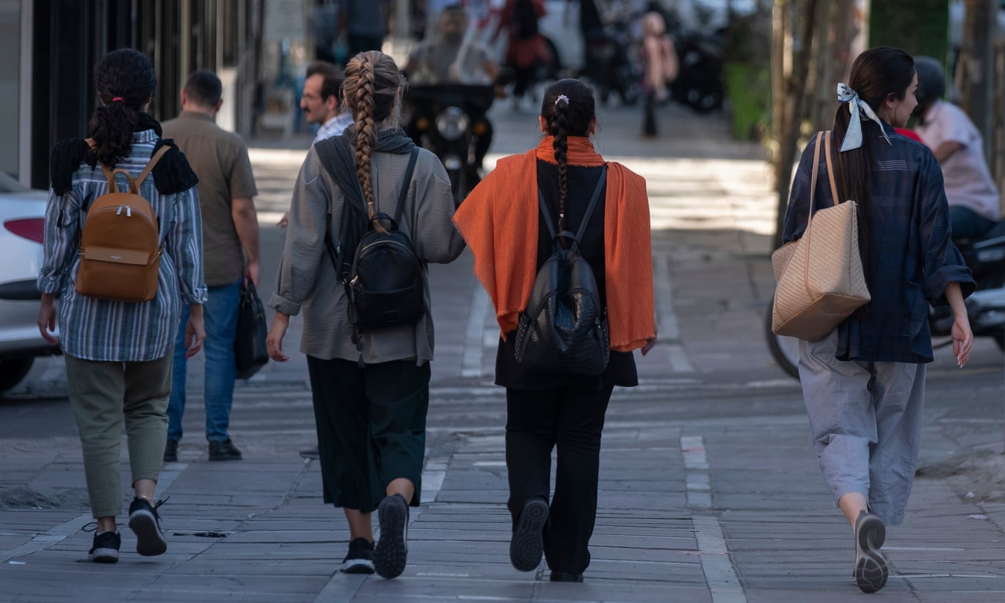 Iranian women without wearing mandatory headscarves, walk along an avenue in downtown Tehran, 12 September 2023