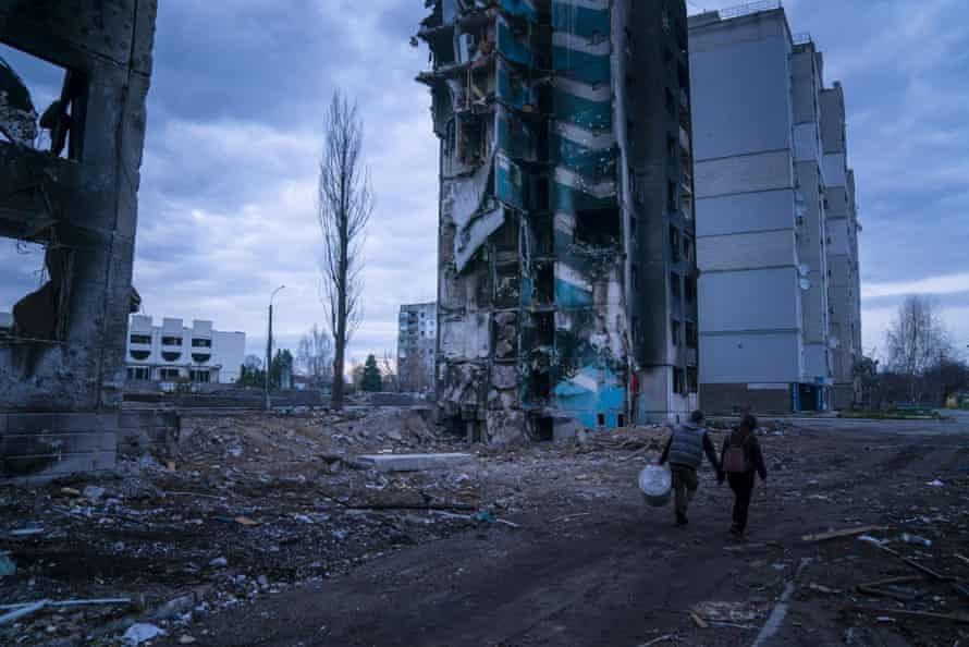 Nikolai Ponamarenko and his wife Julia retrieve a water tank from their apartment building after Russian missile strikes hit the town of Borodyanka.