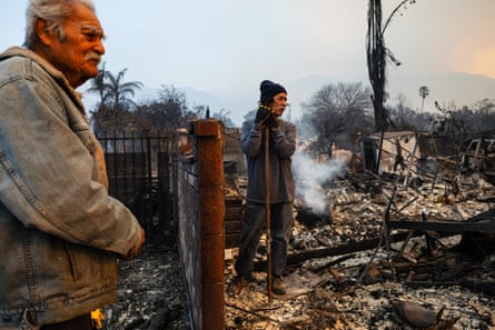 two people standing among ruins from a fire