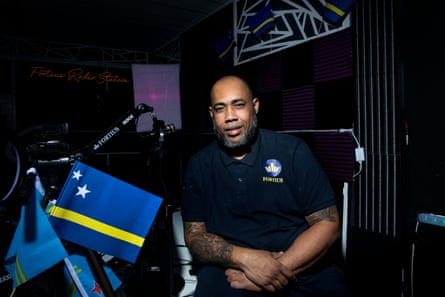 DJ sat at the dj booth looking at camera