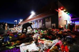 A person lights a candle left at a memorial in front of the LGBTQ+ nightclub Club Q, after a mass shooting there in Colorado Springs, US