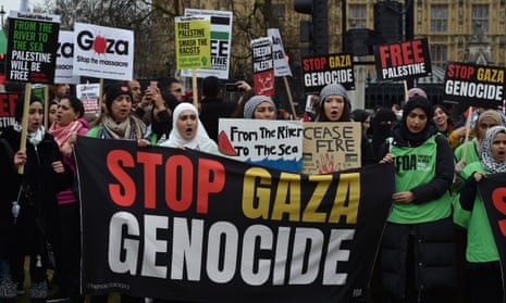 Pro-Palestinian protesters hold banners and placards ahead of a march in support of the Palestinian people in Gaza, in London, Saturday, April 27, 2024.
