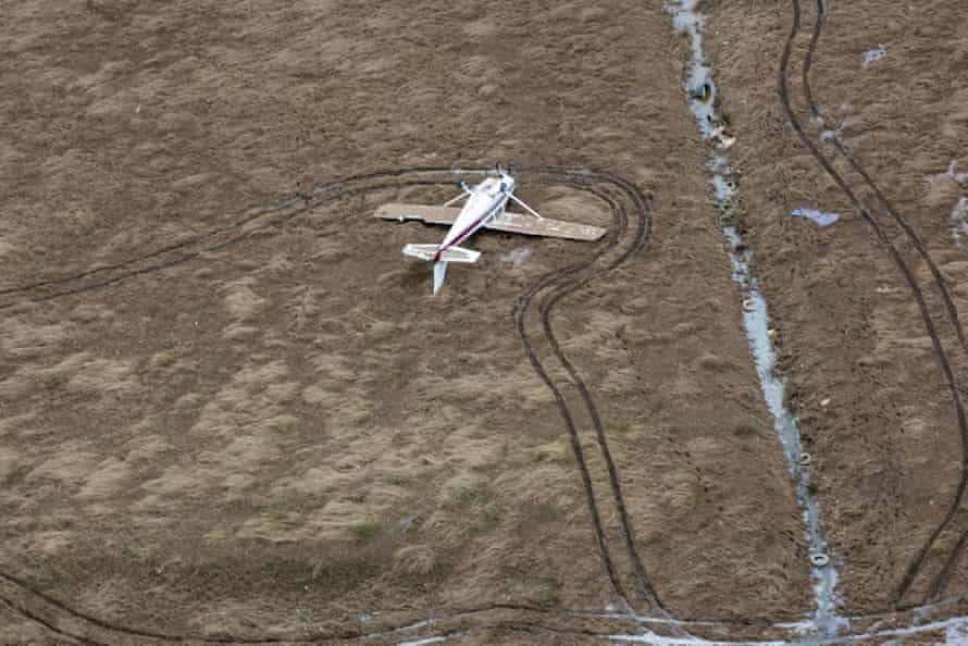 An overturned light plane on the ground near the floods in the Lismore region