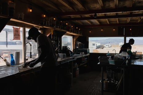 Two people washing dishes inside