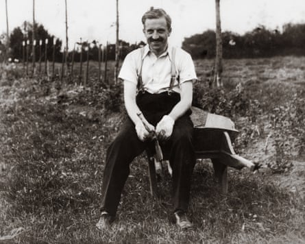 A black and white image of David Strain, a linen merchant who documented the lives of gay people in 1930s Belfast, sitting on a wheelbarrow in some grassland