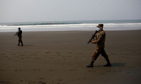 Salvadoran soldiers walk during a patrol at El Majahual beach during a quarantine throughout the country, as the government undertakes steadily stricter measures to prevent the spread of the coronavirus disease