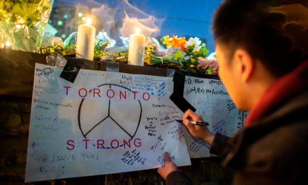 A mourner writes a message during a vigil near the site of the van attack in Toronto, Canada, on 24 April 2018. 