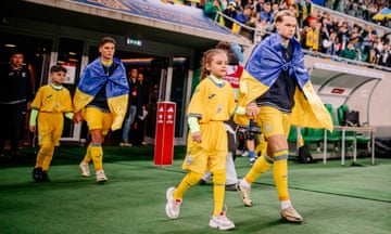 Mykhailo Mudryk is accompanied on to the pitch before Ukraine’s playoff victory against Iceland