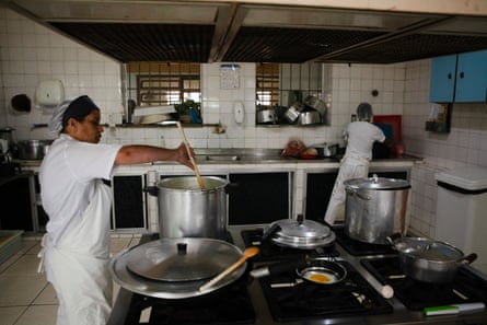 Dois chefs mexem comida no fogão em uma cozinha industrial