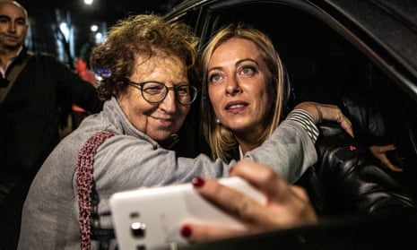 Giorgia Meloni (right) takes a selfie with a supporter after casting her vote at a polling station.