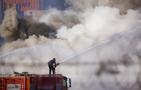 A firefighter works at the scene of the fire in the port of Iskenderun.