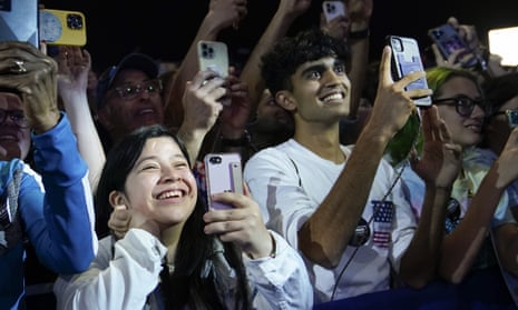 young people hold up phones