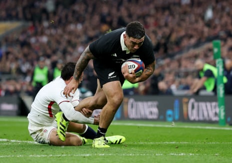 New Zealand's Codie Taylor slips the tackle from England's Alex Mitchell before going over for the All Black's second try.