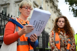 An activist from the Insulate Britain campaign with a letter for Boris Johnson outside Downing Street today. The group, which wants the government to properly insulate all homes in Britain, is suspending its road-blocking protests until 25 October.