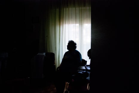 Silhouette of elderly woman alone in dark room.