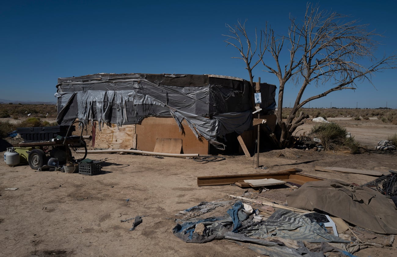 Wood and tarp form a makeshift shelter in the desert