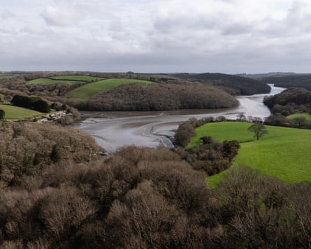 An aerial view of a broad waterway winding around fields and woodland.