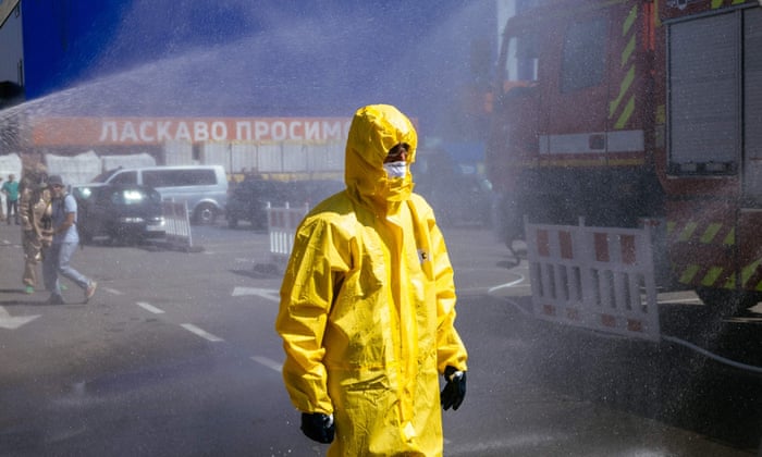 A Ukrainian state emergency service worker stands by a vehicle being hosed down