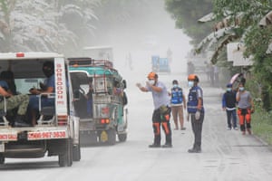 Provincial disaster risk reduction management officers guide vehicles passing through Juban town in Sorsogon province