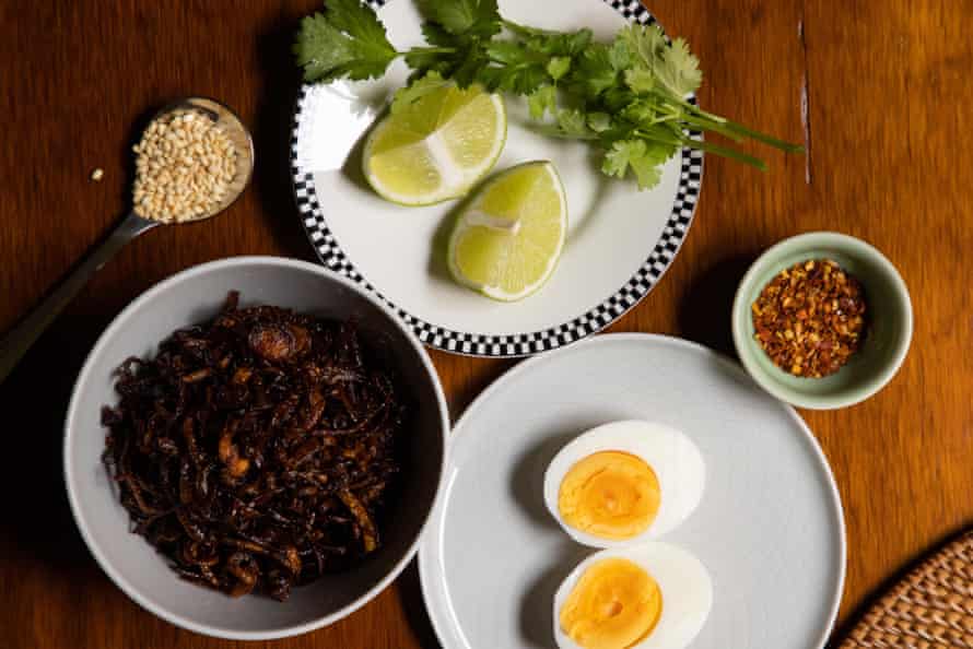fried shallots, lime wedges and coriander sprigs, chilli flakes, boiled egg