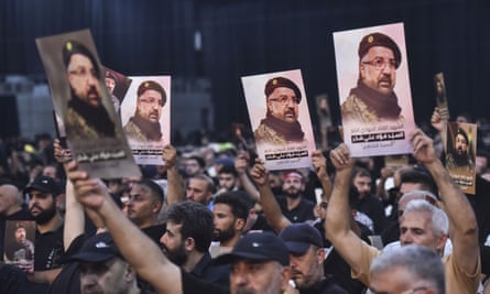 Crowds holding up images of Fuad Shukr during a funeral ceremony in Beirut.