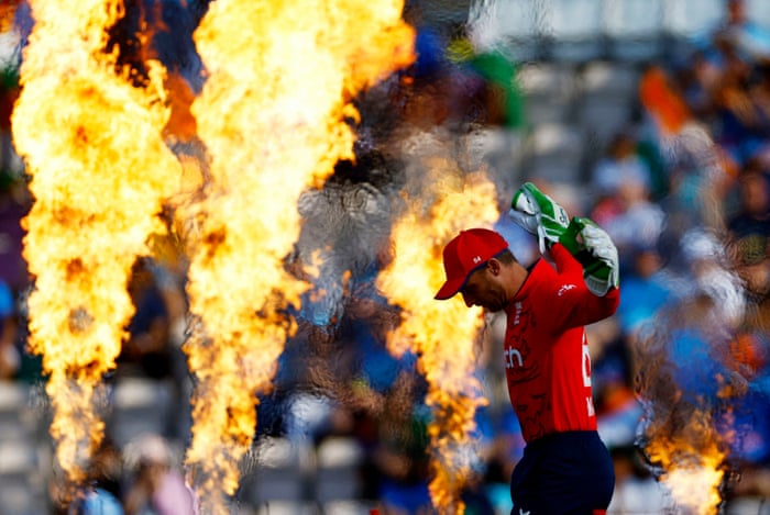 England’s Jos Buttler walks out past the pyros as he takes to the field.