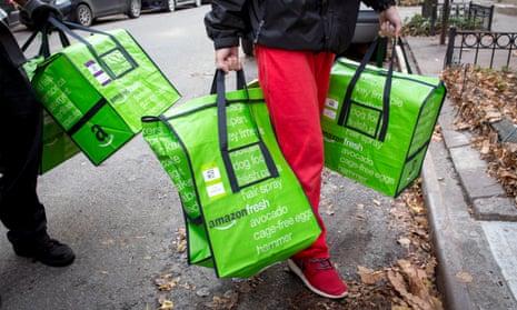 Amazon workers deliver groceries in New York. The delivery bags could soon be a familiar sight in Britain.
