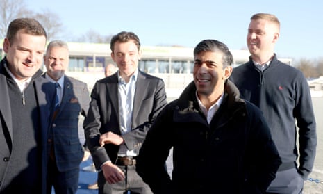 Rishi Sunak stands outside with a group of four other men