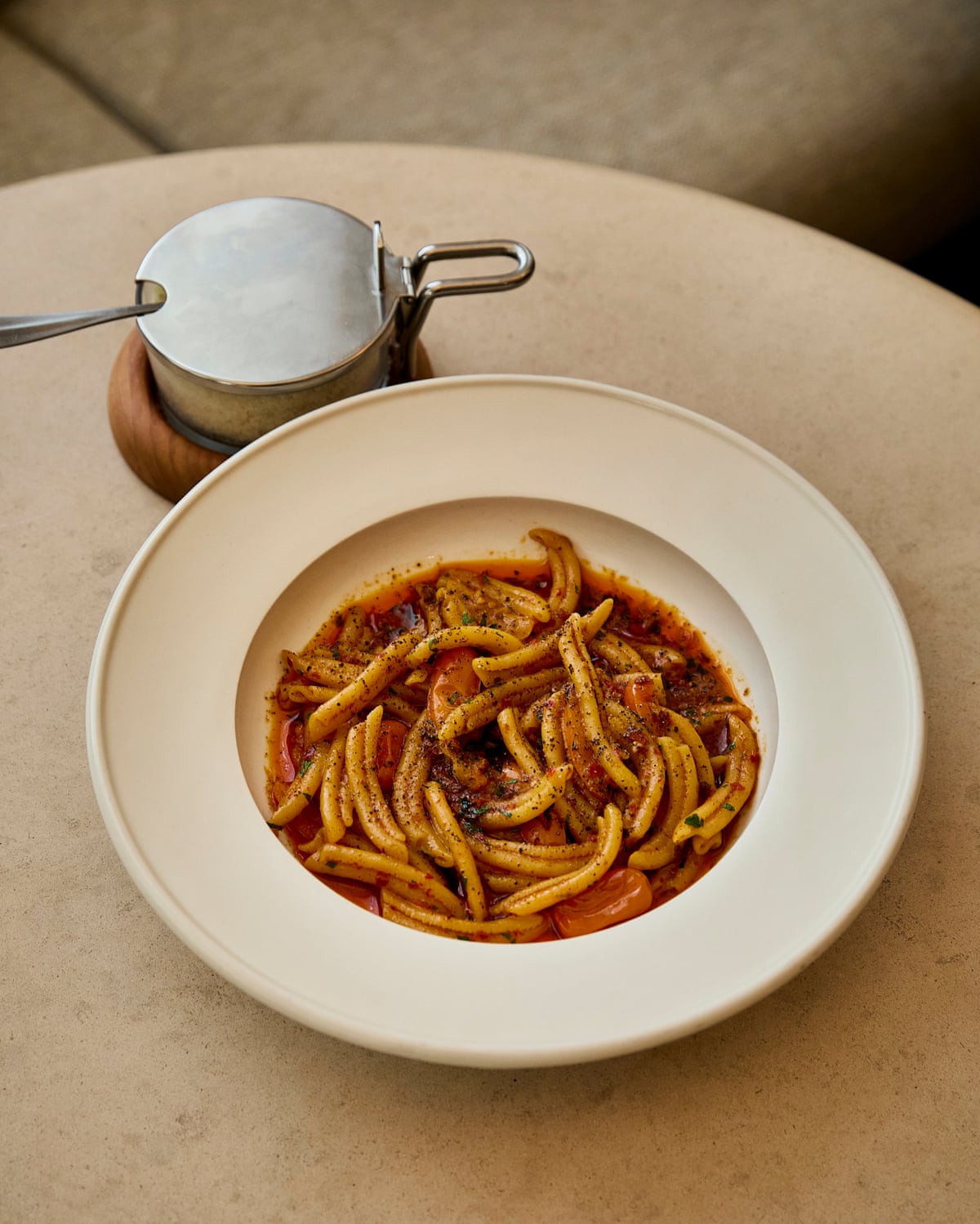 A bowl of ’nduja strozzapreti with a jar beside it