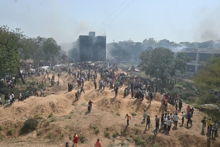 Smoke rising in the distance and people looking at the site