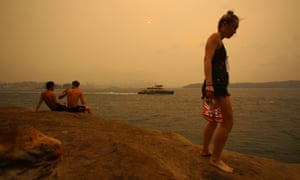 Những người đi biển đứng trên một vách đá khi khói mù mịt từ đám cháy rừng ở Sydney CBD, ngày 21 tháng 12 năm 2019