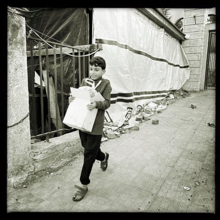 A child moves some food from a building next to al-Amal hospital